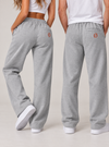 NØMADZ grey unisex joggers with orange logo on the back worn by male and female models
