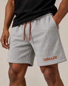 NØMADZ grey men's shorts with terracotta orange drawstring and embroidered logo worn by a model