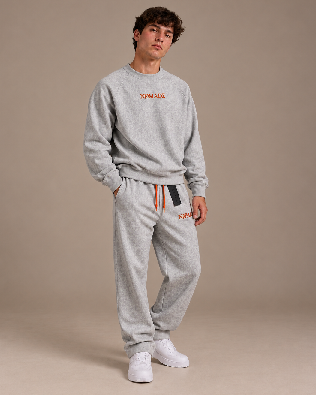NØMADZ grey sweater and joggers set with orange embroidery worn by a male model