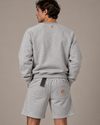 NØMADZ grey sweater and men's shorts set with orange Ø embroidery on the back worn by a model